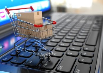 E-commerce. Shopping cart with cardboard boxes on laptop. 3d